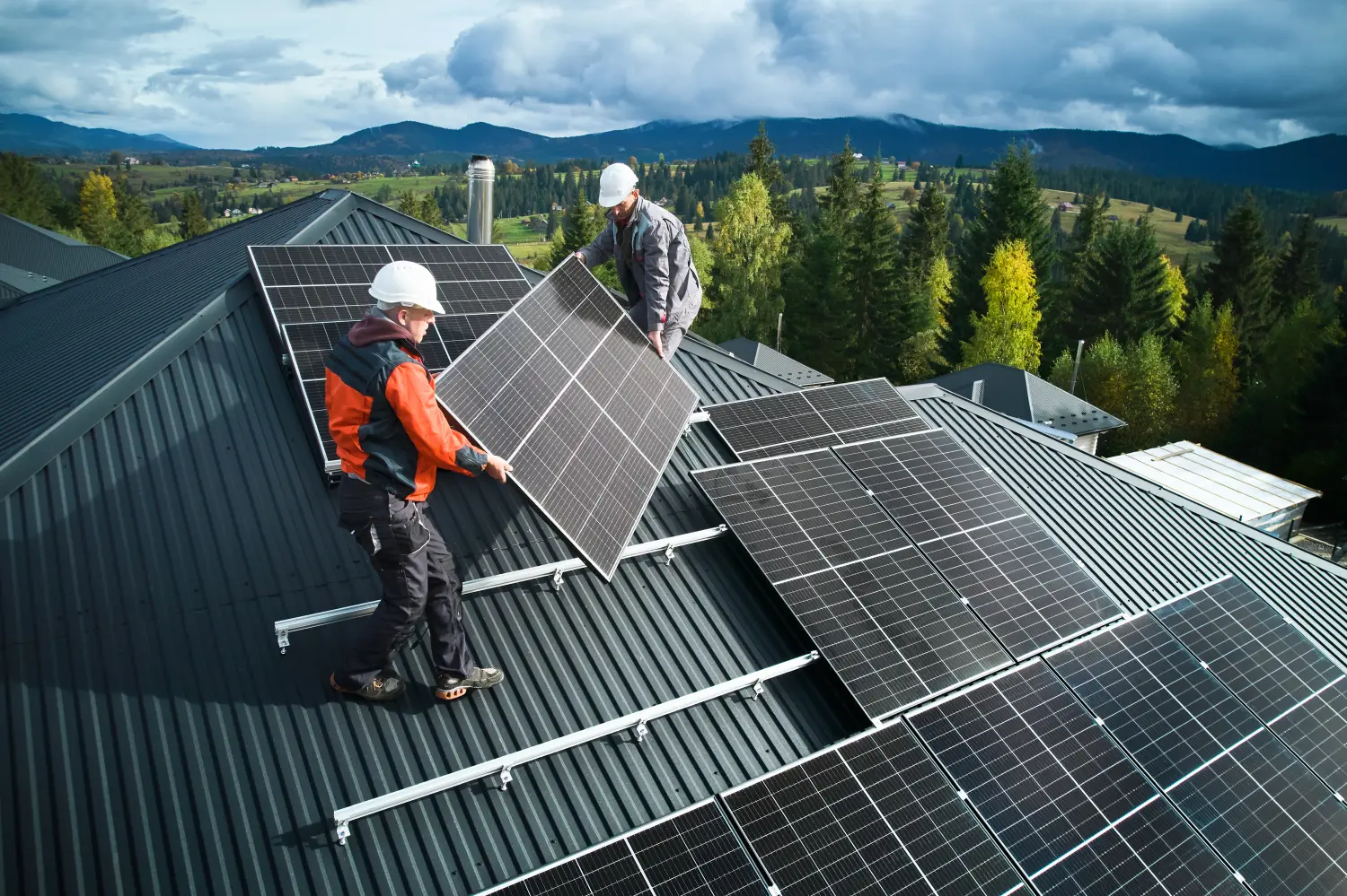 Arbeiter bauen Solaranlage auf dem Dach eines Hauses.